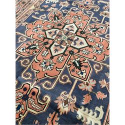 Persian ivory and peach ground, overall geometric design, the field with central star medallion surround stylised leaf motifs, guarded geometric design border