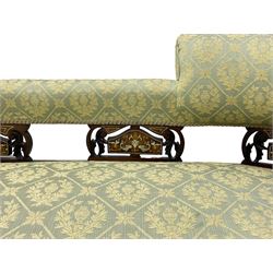 Late Victorian walnut salon settee or chaise lounge, double-ended with rolled back and curved end, upholstered in light aquamarine fabric with raised repeating lozenge pattern, decorated with laurel leaf wreaths and urns, three pierced splats carved with curled leaves, inlaid with dolphins and scrolled foliate motifs in simulated ivory and boxwood, on tapering ring turned supports with brass and ceramic castors (L166, D60, H70cm); together with matching tub-shaped armchair (W61cm, H73cm, D66cm)  