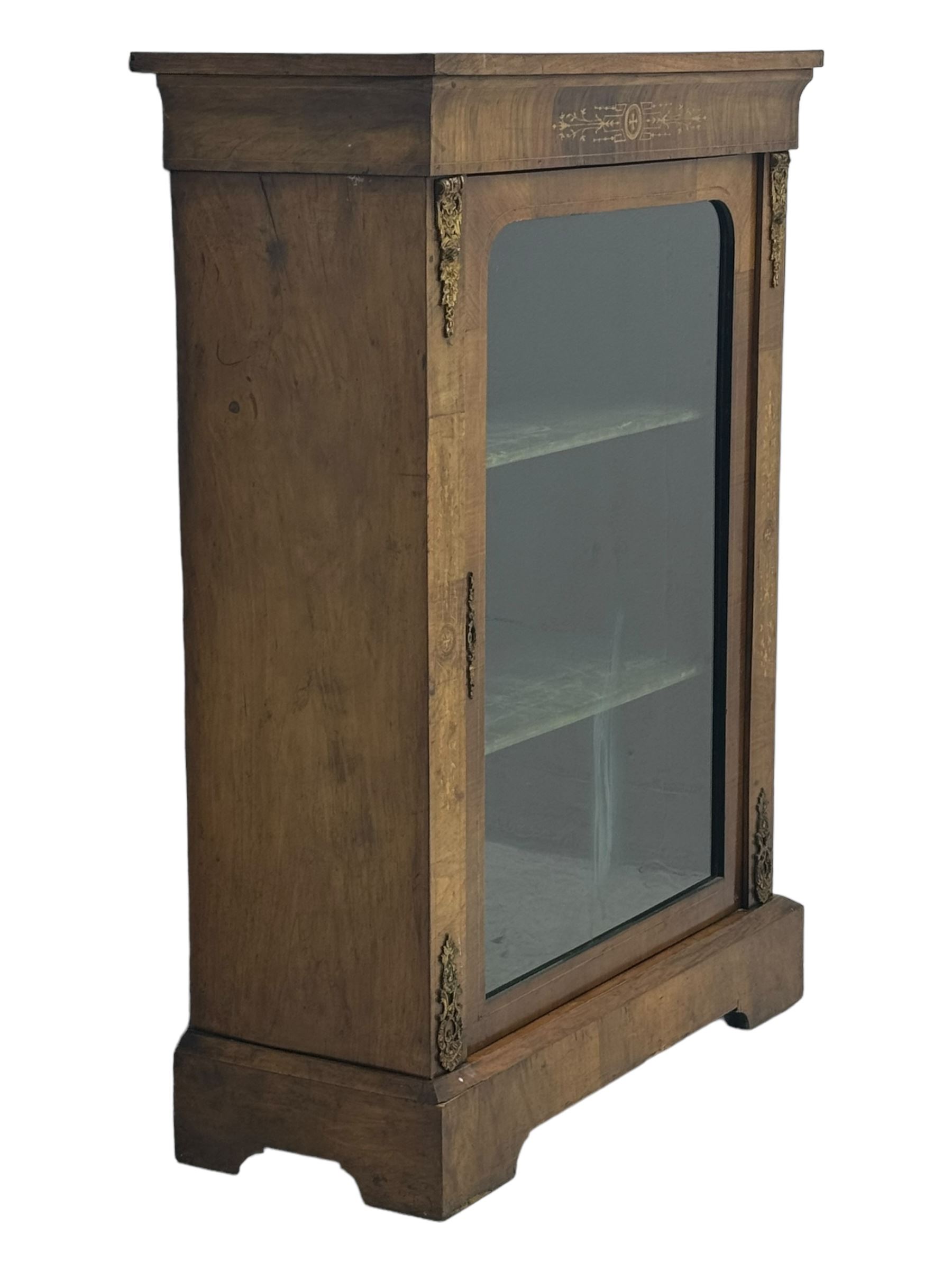 Late Victorian walnut pier cabinet, projecting cornice over frieze inlaid with foliate motifs, single glazed door flanked by ormolu mounts, enclosing shelved interior, on plinth base