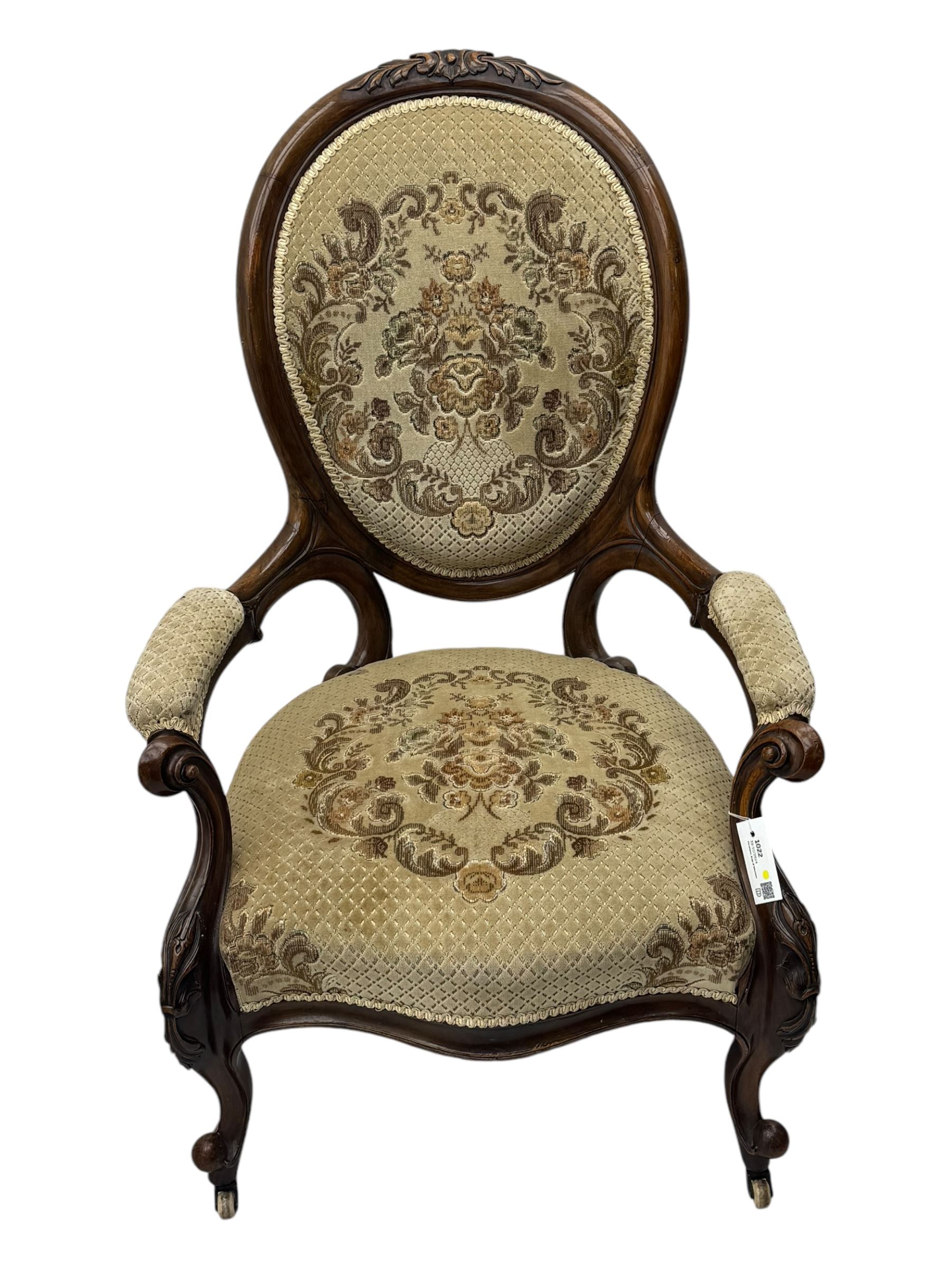 Pair of Victorian walnut lady's and gentleman's drawing room chairs, arched cresting rail carved with cartouche and extending foliage, upholstered in floral pattern fabric, on foliate carved cabriole feet