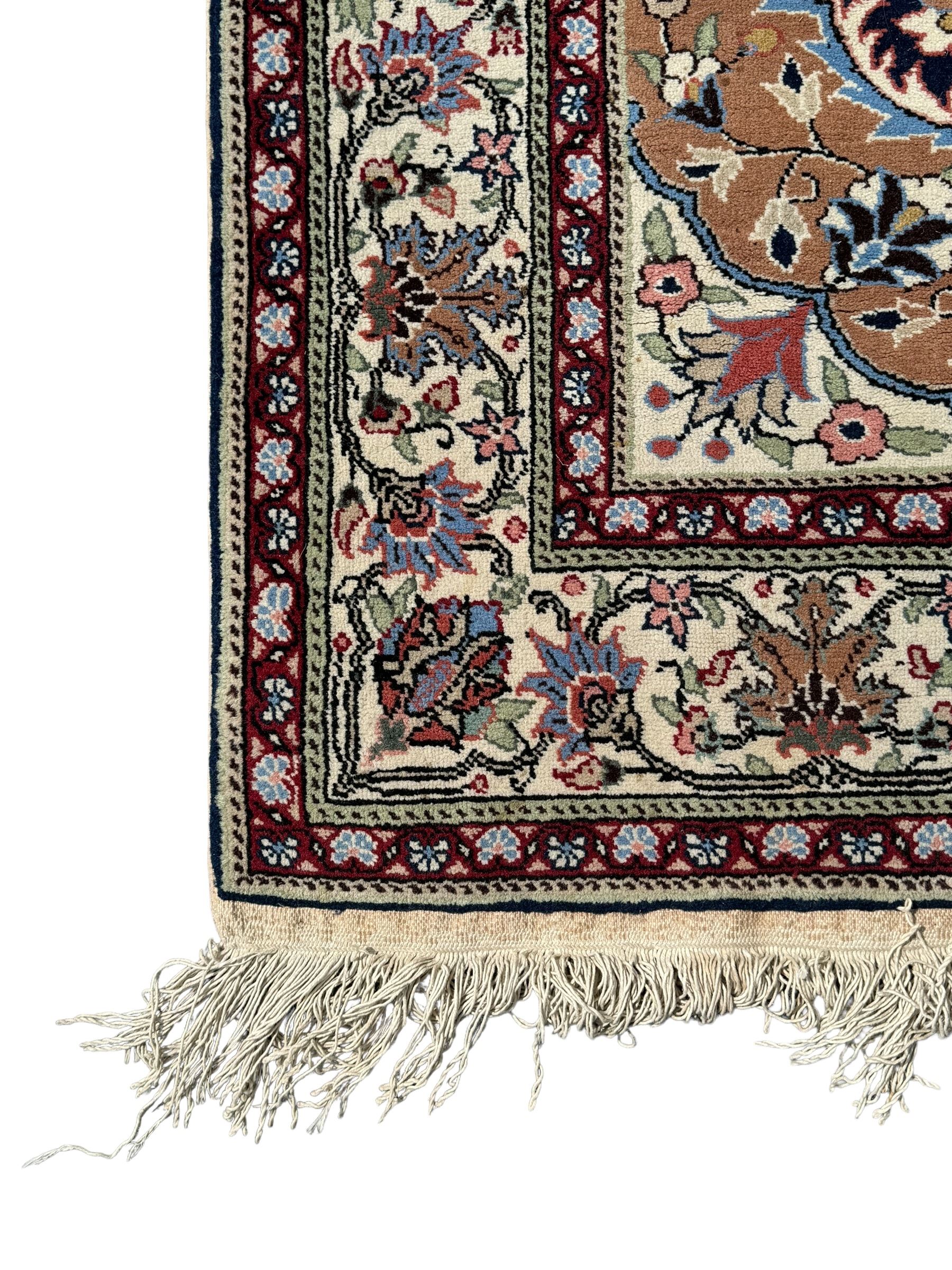 Indo-Persian indigo ground rug, the floral design peach medallion surrounded by trailing and interlaced branches and flower heads, the main border decorated with repeating stylised plant motifs within floral guard stripes 