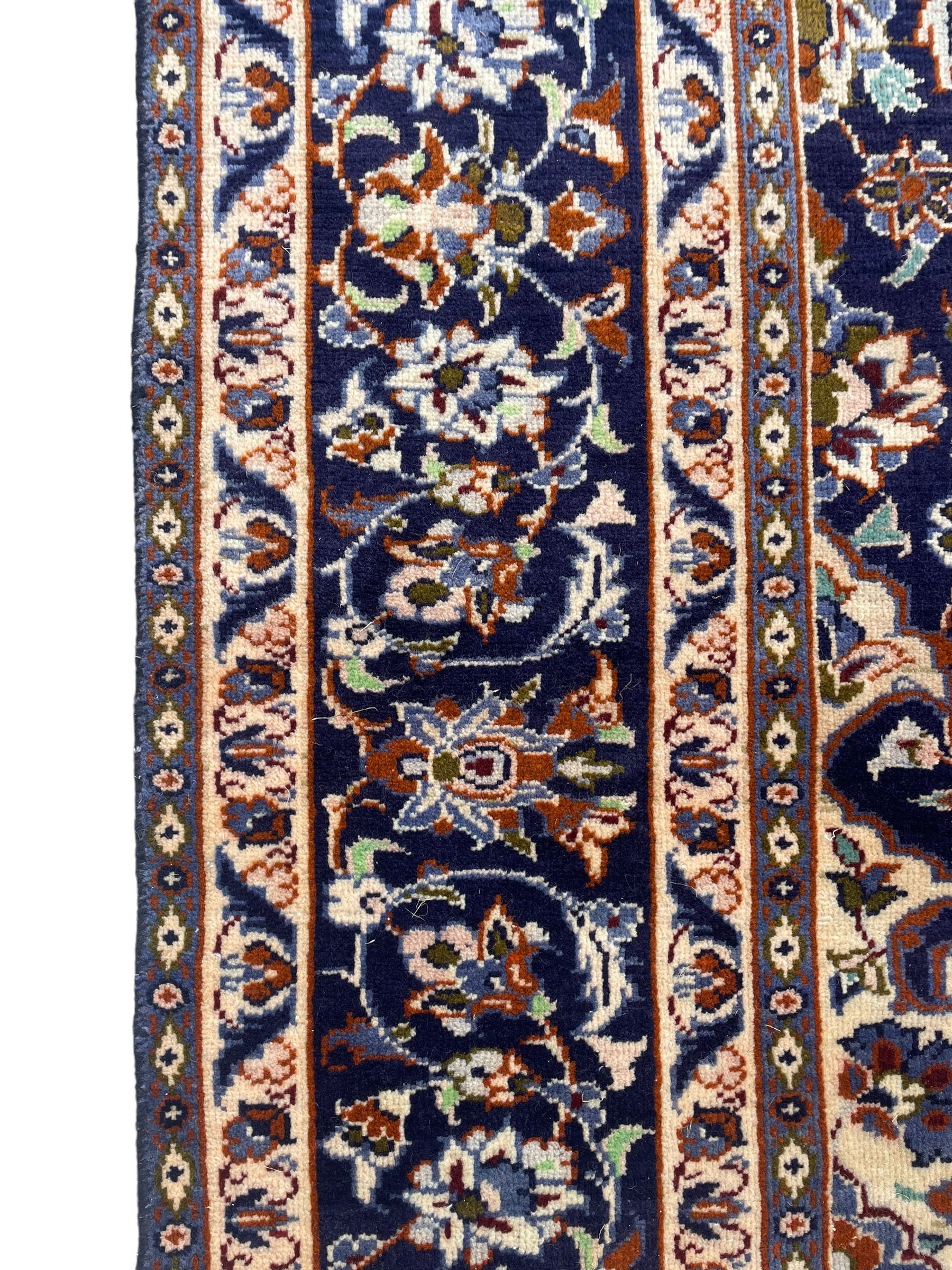 Persian Nain indigo ground, arabesque design, central start medallion surrounded by interlacing branches and palmettes, scrolling border with repeating stylised plant motifs, within guard stripes