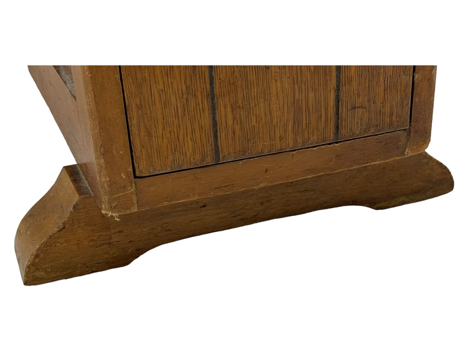 Early 20th century oak drop-leaf table, in the style of Harris Lebus, featuring rectangular top over central pedestal base, with two drawers and two cupboards, on gateleg supports