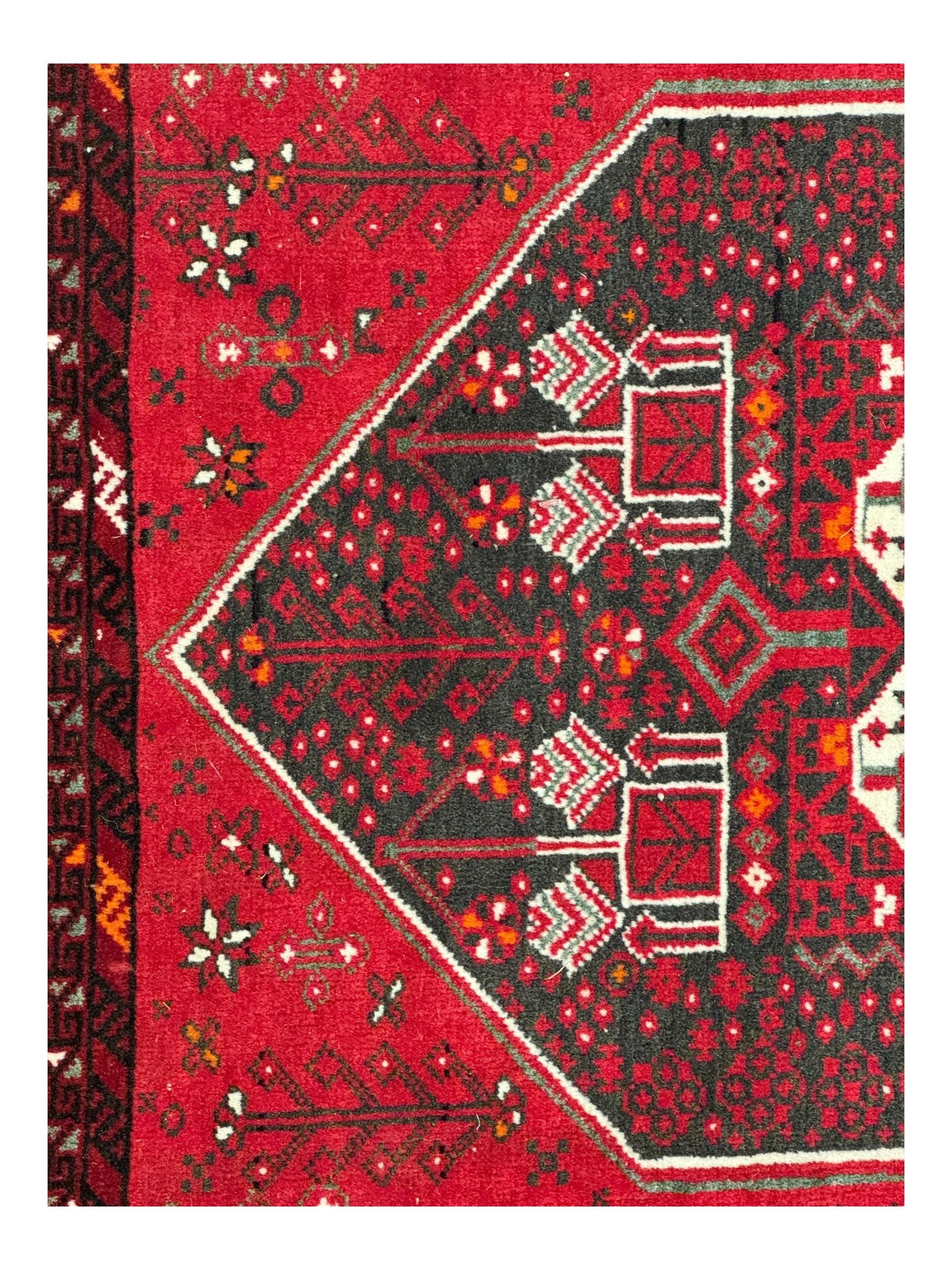 Persian Heriz red ground rug, the field with three large central medallions in indigo and ivory, border with geometric pattern within multiple guard stripes (119cm x 189cm); Persian Yomut crimson ground rug, central field with ivory medallion with geometric motifs, main border with geometric pattern within multiple guard stripes (88cm x 133cm)