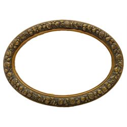 20th century giltwood and gesso oval wall mirror, the frame decorated with moulded fruit and foliage, bevelled mirror plate 