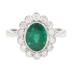 18ct white gold oval cut emerald and milgrain set, round brilliant cut diamond cluster rin...