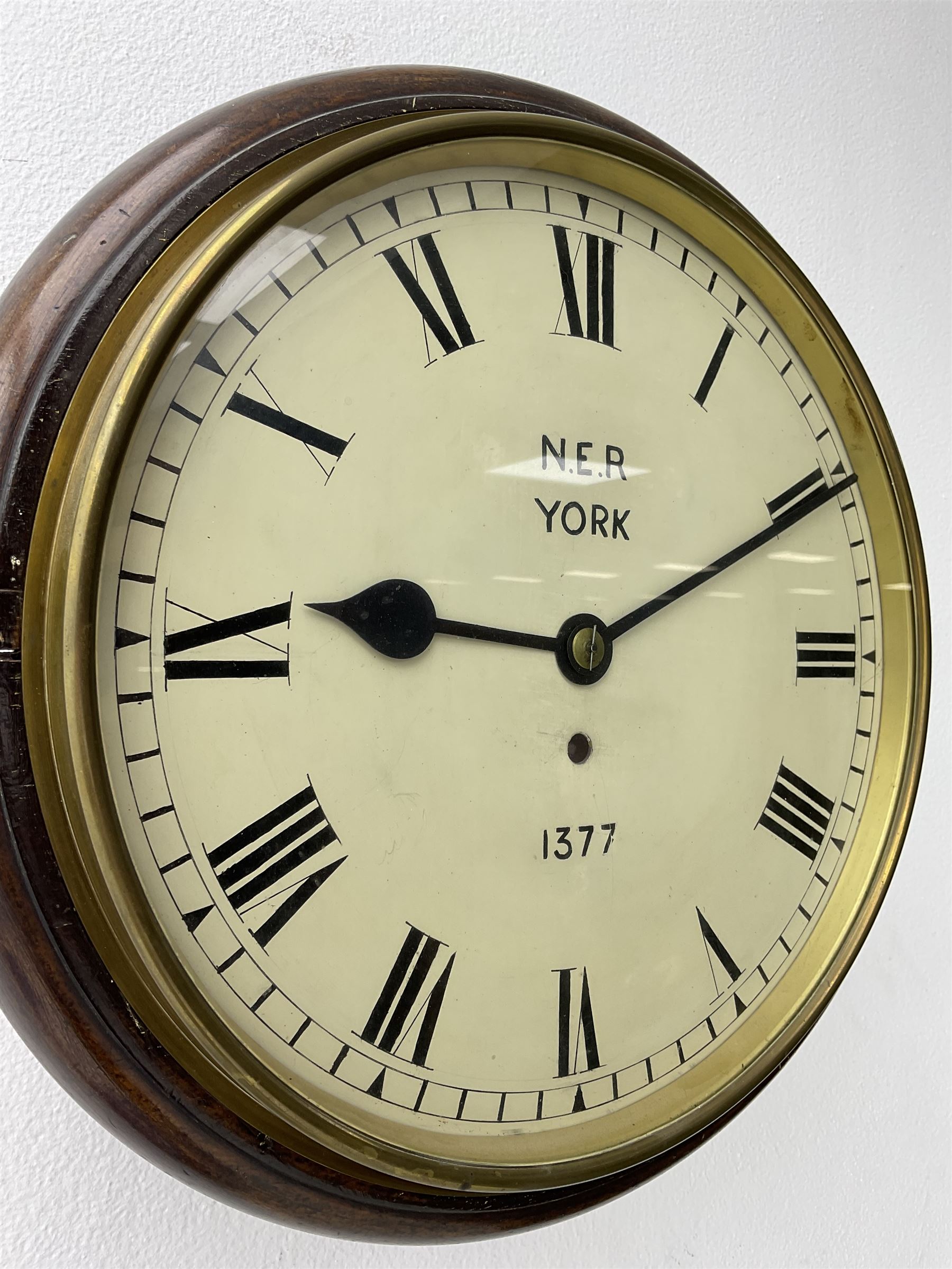 English - 8-day single train Fusee wall clock, with a mahogany dial surround and brass bezel, painted dial with Roman numerals , minute track and steel spade hands, dial inscribed N.E.R. YORK .1377. wire driven fusee with square plates and recoil anchor escapement. With pendulum. 