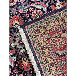 Persian Farahan indigo ground rug, the field decorated with large repeating floral herati motifs, crimson ground border decorated with palmettes and trailing leafy branch, within guard stripes 