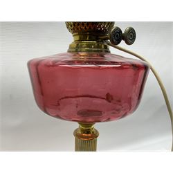 Victorian corinthian column oil lamp, with red glass reservoir and later converted for electricity, H45cm