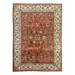 Persian Kashan peach ground rug, the field decorated with swirling leafy branches and styl...