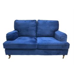 Howard design - two-seat sofa upholstered in blue fabric, traditional shape with rolled arms, on walnut finish turned feet with brushed metal cups and castors