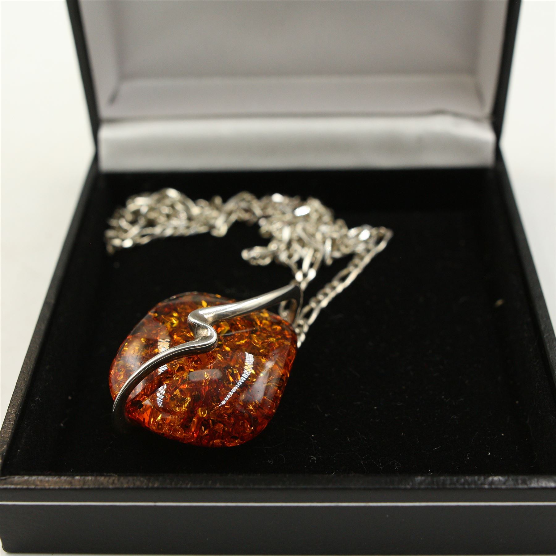 Group of silver amber jewellery, including three amber pendant necklaces, an amber bracelet, amber brooch and two amber rings