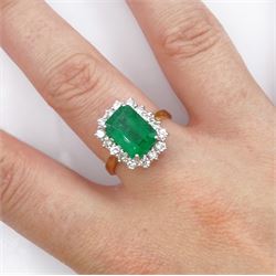 18ct gold emerald cut emerald and round brilliant cut diamond cluster ring, hallmarked, emerald approx 3.80 carat, total diamond weight approx 0.50 carat