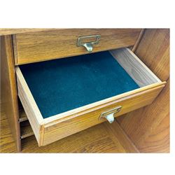 Early 20th century oak tambour roll-top desk, the top with fitted interior including drawers, pigeonholes and compartments, the twin pedestals fitted with four drawers with carved handles, supported by plinth base 