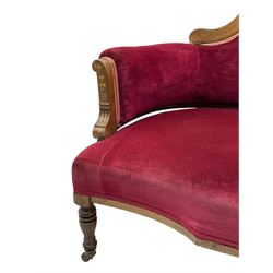 Late Victorian inlaid walnut two seat settee, the shaped cresting rail decorated with foliate inlays and boxwood stringing, upholstered in crimson velvet with sprung seat, raised on turned and fluted supports with ceramic castors