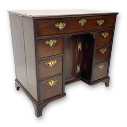 George III mahogany kneehole desk, moulded rectangular top over one long drawer, six short drawers and recessed panelled cupboard, cock-bead moulded frame, fitted with shaped brass handle plates with engraved decoration, on bracket feet 