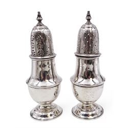 Pair of Victorian silver sugar casters, of typical waisted form, the removable pierced cover with urn finial, upon domed circular foot, hallmarked Sheffield 1880, maker's mark WB, H14.5cm