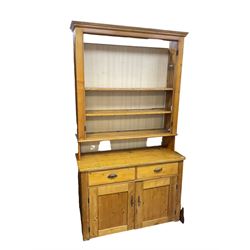 19th century polished pine dresser, the dresser rack fitted with three shelves, the base with two drawers over two panelled cupboards