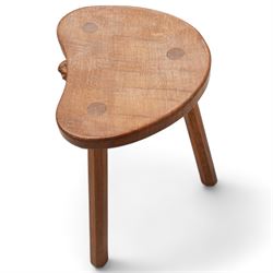 Mouseman - oak three-legged stool, dished kidney-shaped seat on three octagonal splayed supports, carved with mouse signature, by the workshop of Robert Thompson, Kilburn