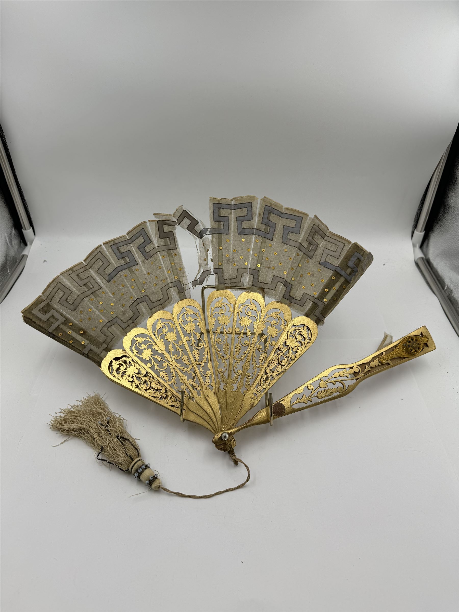 19th century carved gilt wood fan by Eugene Rimmel, the guards and sticks with pierced floral decoration, the chiffon leaf worked with sequins, with silk beaded tassel, stamped E.Rimmel 36 Strand London, with a purple silk lined box 