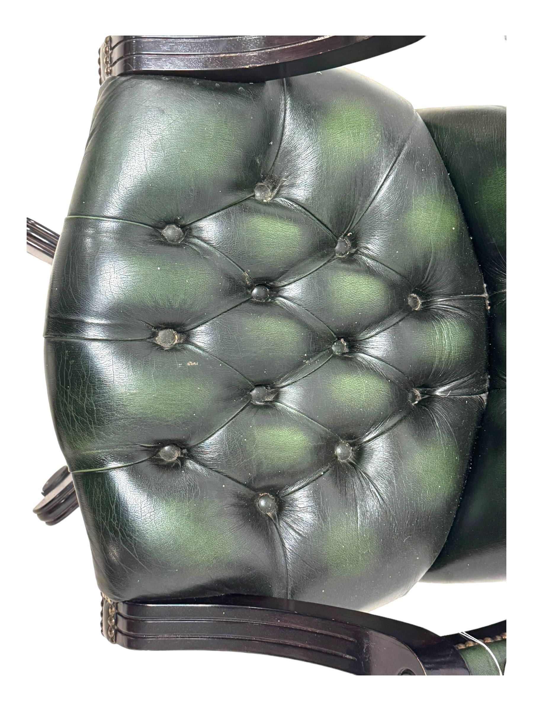 Victorian design Captains swivel desk chair, rolled tub shaped back with open arms, upholstered in deep buttoned green leather with studwork border