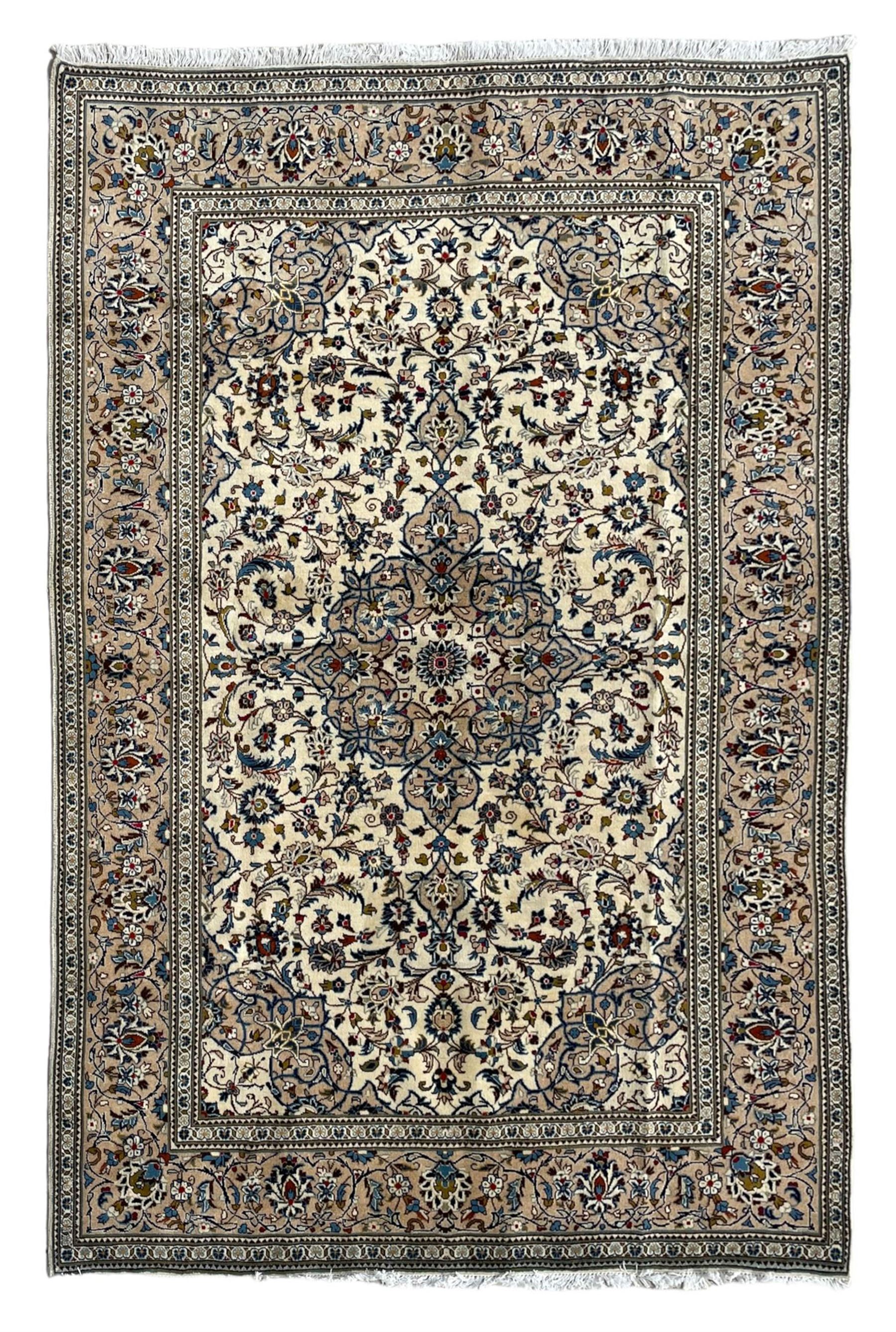 Persian Kashan ivory ground rug, central floral medallion surrounded by interlacing leafy branches and stylised plant motifs, scrolling spandrels, the border decorated with trailing branch and repeating palmettes, within floral pattern guard stripes 