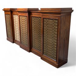 Large 19th century figured mahogany bookcase, enclosed by five brass grille panel doors, the interior fitted with adjustable shelves, double drop centre and break front with raised stepped tops, on plinth base 