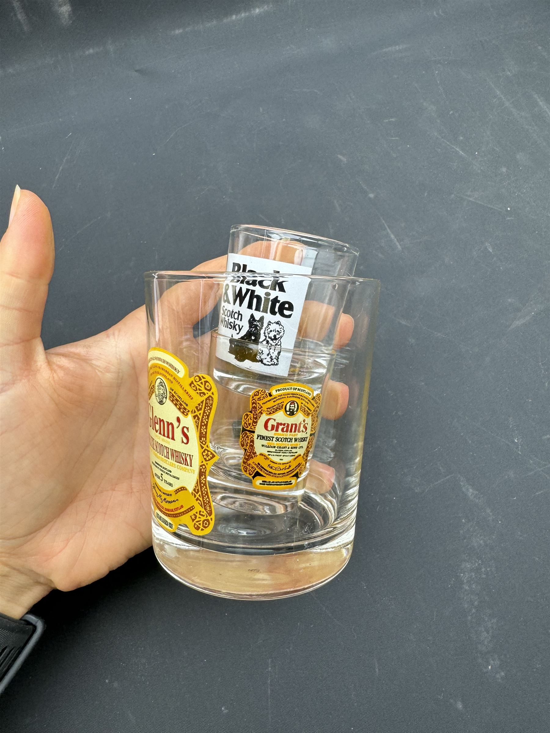 Thirteen ceramic whisky jugs bearing various advertising, including Long John, Jamesons, Ballantines etc, together with whisky glasses 