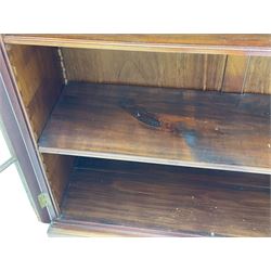 Early 20th century mahogany bookcase, projecting dentil cornice over blind fretwork frieze, enclosed by two astragal glazed doors, on shaped bracket feet 