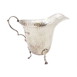 Edwardian silver jug, of helmet form with planished decoration throughout, upon three hoof feet, hallmarked Charles Boyton & Son Ltd, London 1906, H9cm