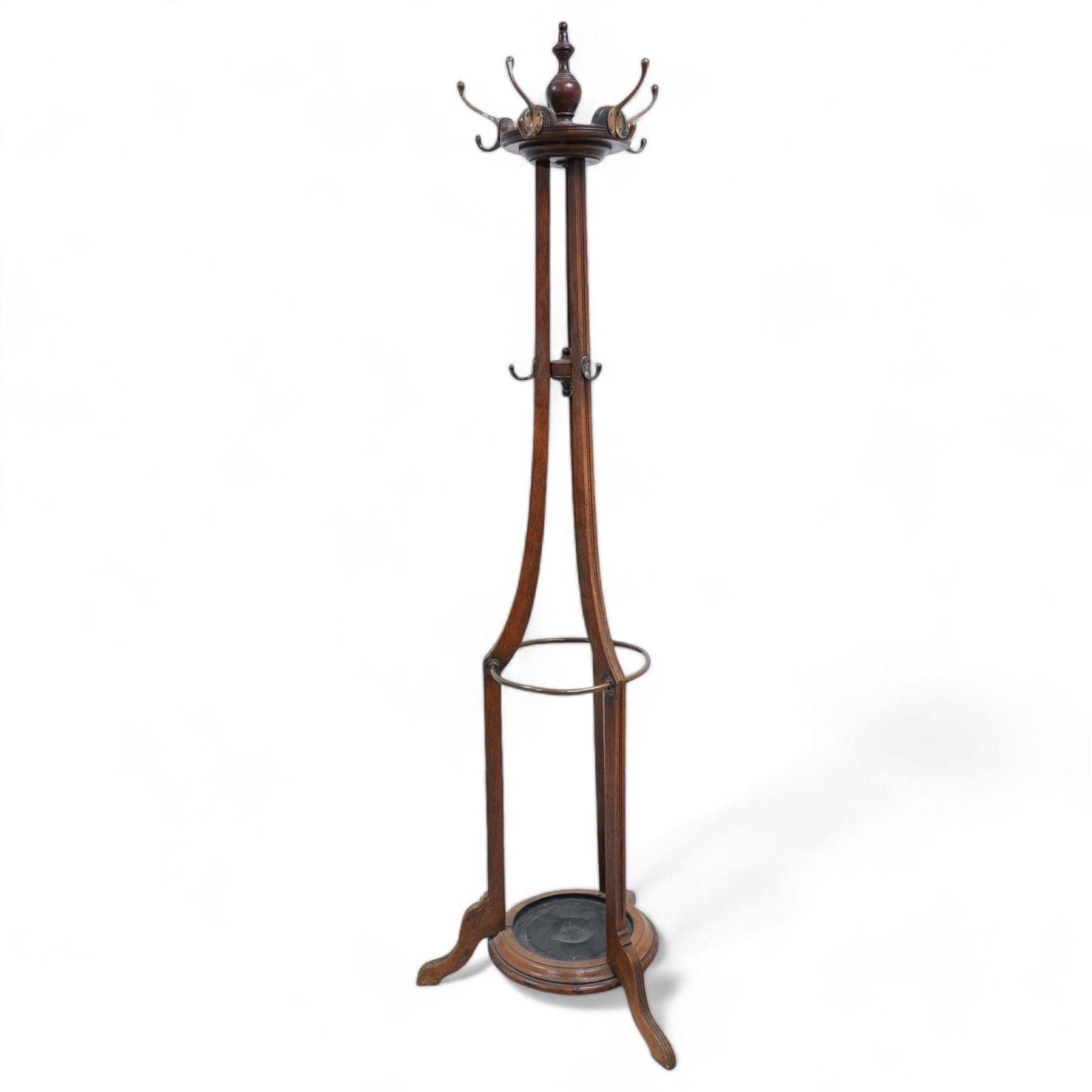 Late 19th century oak hat and coat hallstand, on three shaped and moulded supports with out splayed feet, fitted with hooks and turned finial 