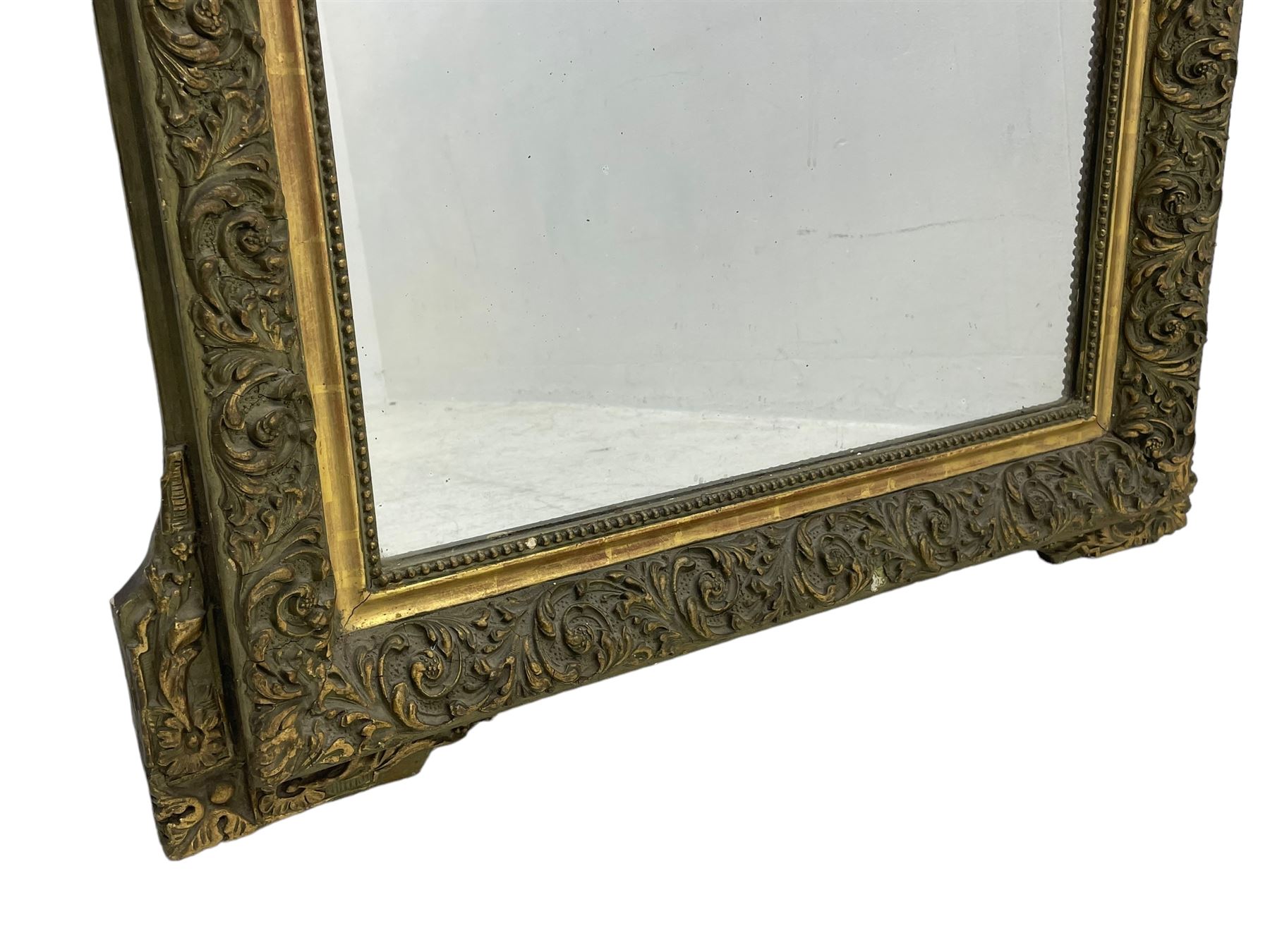 Victorian giltwood and gesso wall mirror, pierced shell cartouche pediment decorated with C-scrolls and curled leaves, moulded frame with curled acanthus leaf decoration and beaded inner slip, the corner brackets decorated with flower heads 