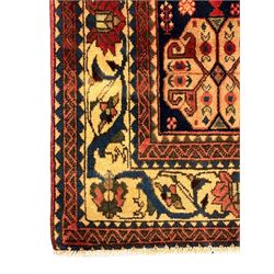 South West Persian Abadeh crimson ground rug, indigo ground with crimson lozenge field, decorated all over with small stylised motifs of flowerheads, hooks, animals and birds, guarded border decorated with trailing leaves and stylised plant motifs 