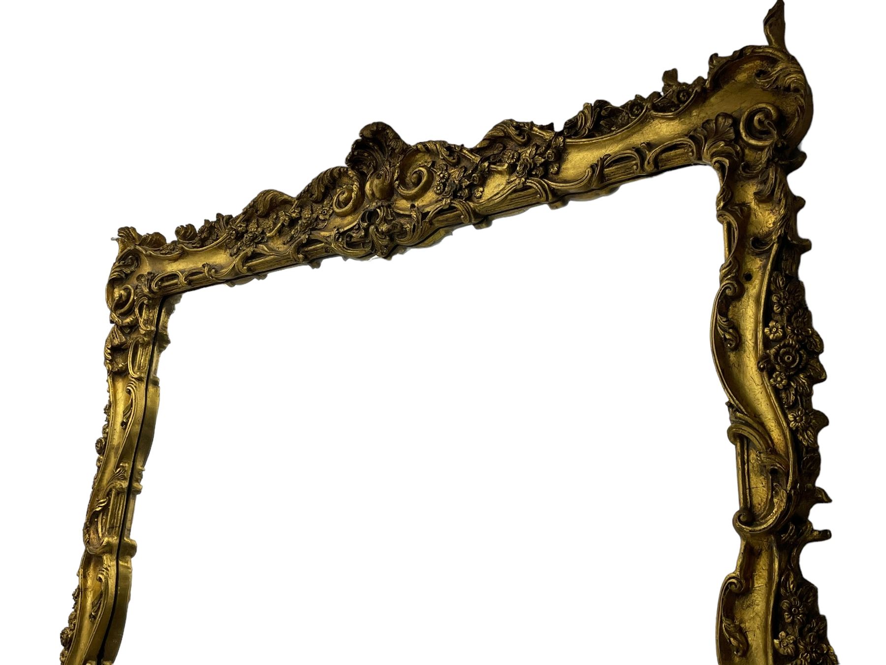 Large gilt framed rectangular wall mirror, shaped and moulded frame decorated with trailing curled acanthus leaves and flower head motifs, bevelled glass plate 