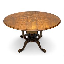 Unusual Victorian figured walnut drop-leaf Sutherland table, moulded drop-leaf oval top, central turned baluster column with quadruple moulded S-scroll supports carved with acanthus leaves, four out-splayed supports with scroll carved terminals, double gate-leg action base, on castors