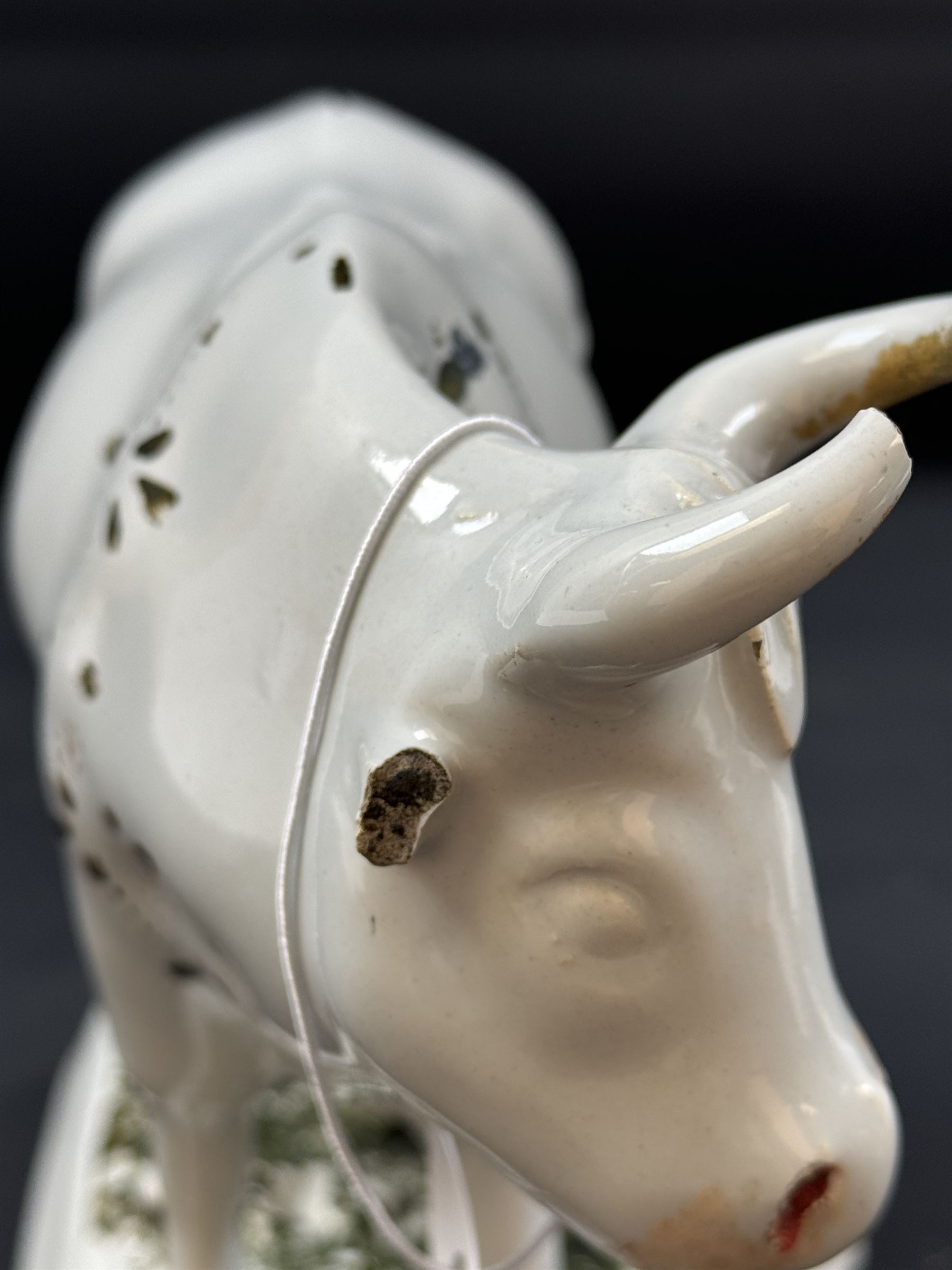 19th century Delft figure group depicting a milkmaid milking a cow, H17.7cm