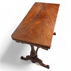 Victorian figured mahogany card table, rectangular swivel and fold-over top with rounded corners and baize lined interior, shaped apron over turned and lobe carved end supports, terminating to scroll and cartouche carved splayed supports united by swell-turned stretcher