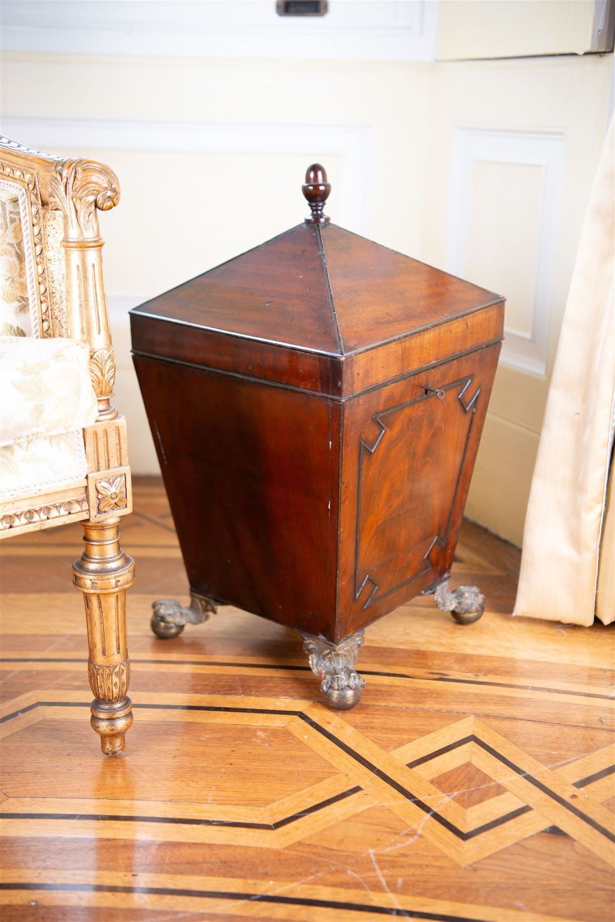 George III mahogany wine cooler or cellarette, the pointed hinged lid with turned final, square tapering body with applied geometric mouldings, on gilt metal and foliate cast ball and claw feet, with metal liner 