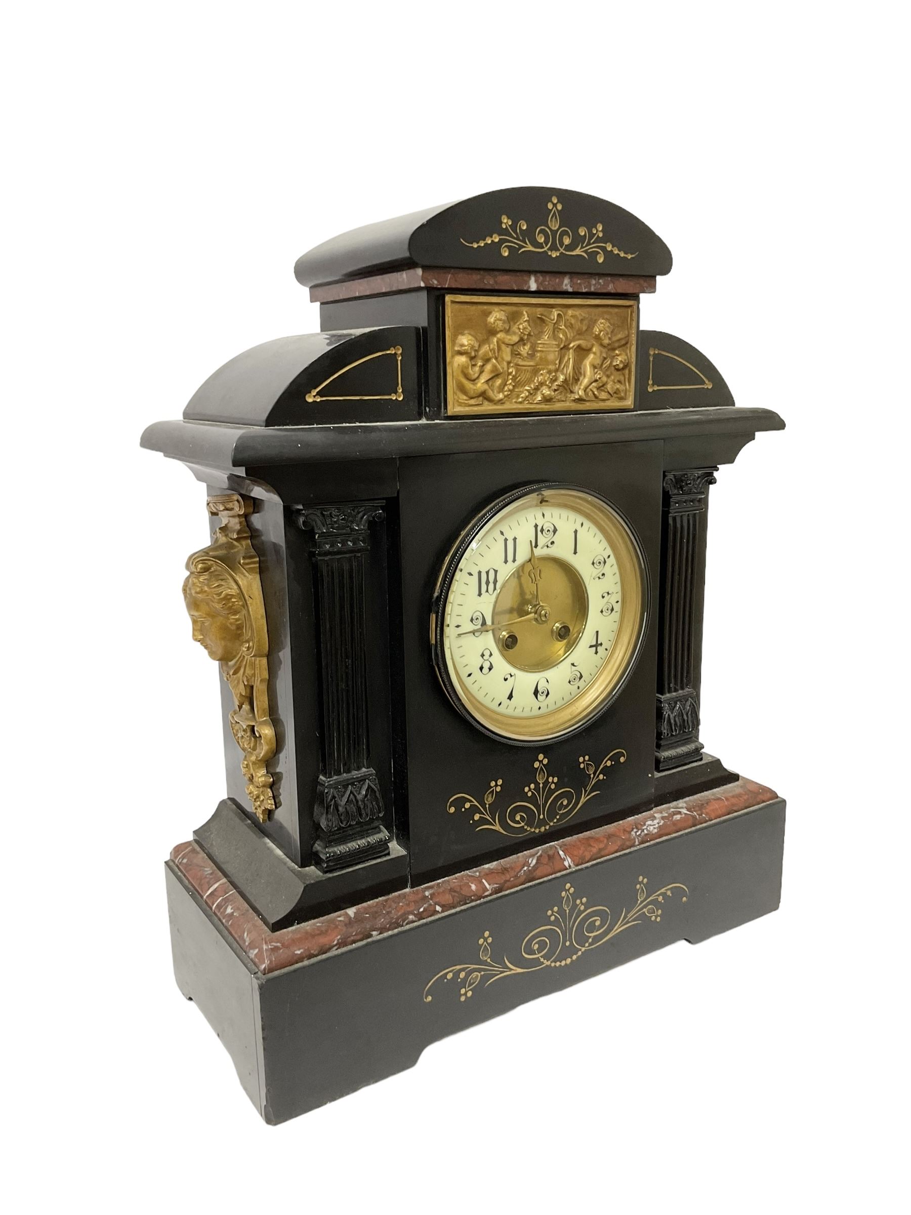 French - late 19th century 8-day Belgium slate mantle clock with incised decoration and contrasting rouge marble inlay, with a gilt repoussé panel to the front and cast cryatid to the sides, two part dial with a gilt centre, Arabic numerals, minute markers and brass fleur di Lis hands, twin train rack striking movement, striking the hours and half hours on a coiled gong. With pendulum. 