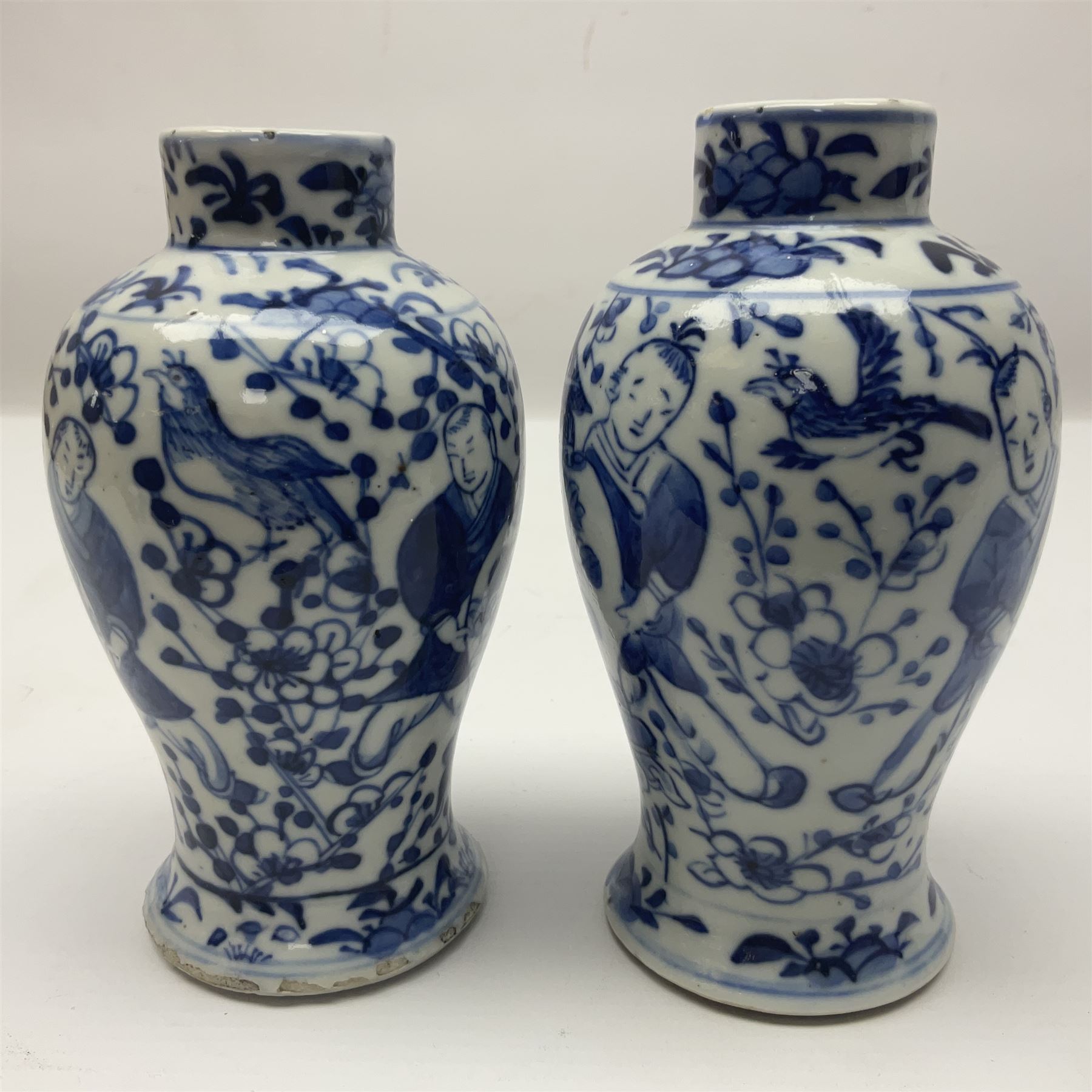 Pair of Chinese blue and white vases, of squat baluster form, each depicting figures holding a ginger jar, with four character Kangxi mark beneath, H13.5cm