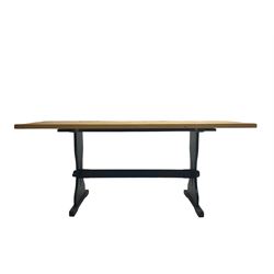 Pine dining table, rectangular top on black painted base, shaped end supports joined by pegged stretcher 