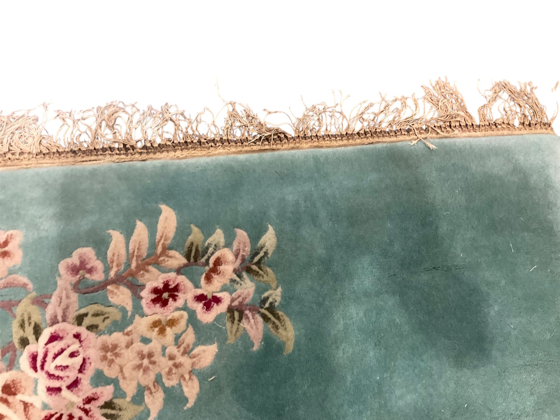 Chinese pale turquoise ground washed woolen rug, the plain field decorated with two large floral bouquet motifs with extending blossom and leafage