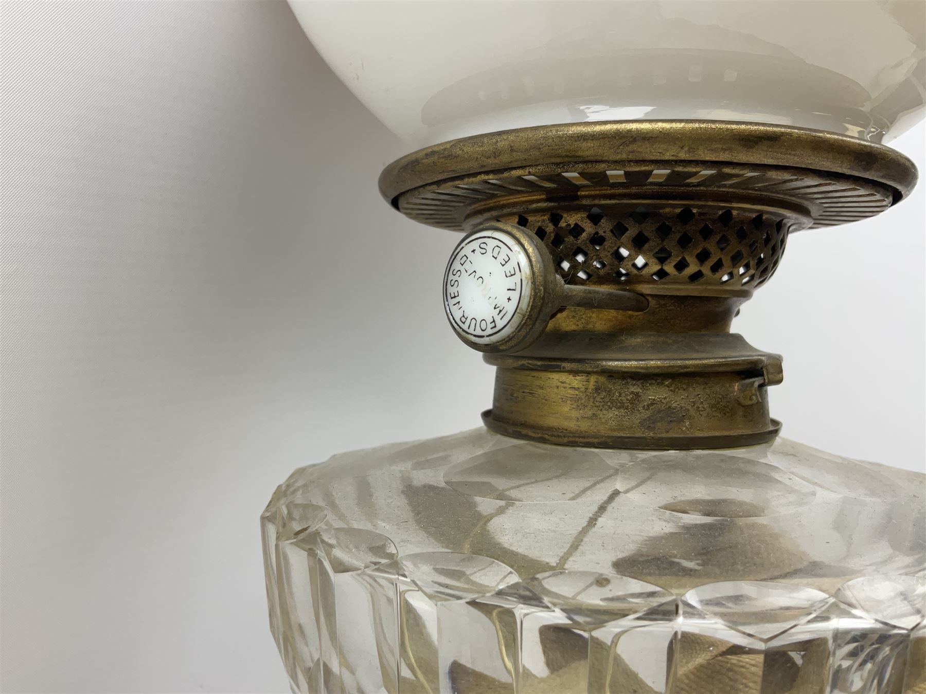 Victorian brass oil lamp converted to electricity, the square stepped base with a reeded doric column leading to a cut clear glass reservoir and burner and spherical shade with printed bird decoration, together with another similar shade and oil lamp parts and accessories etc