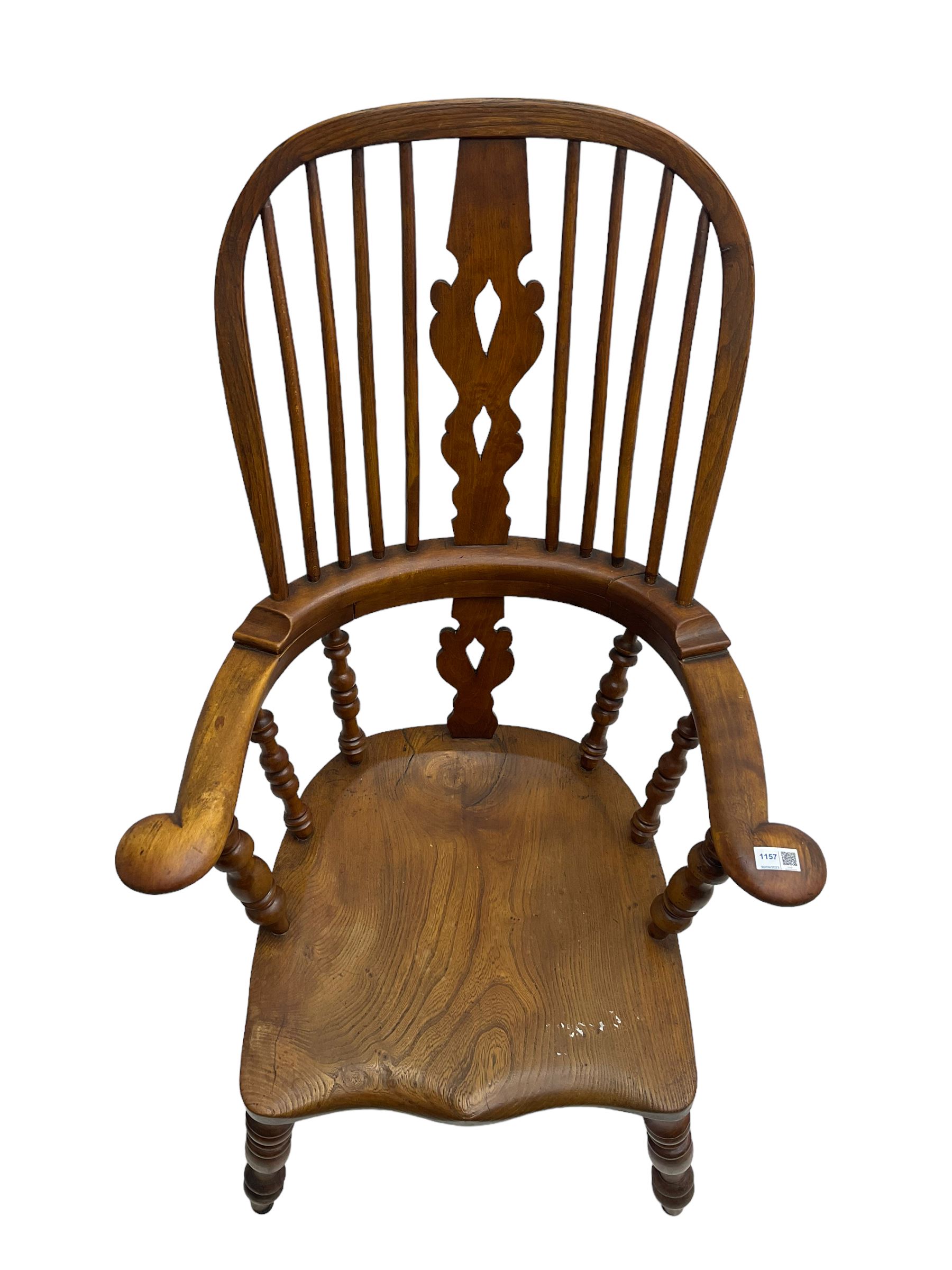 Elm and beech high back Windsor chair,  high hoop back with pierced splat and spindle supports over shaped saddle seat, raised on ring turned supports united by H-stretcher