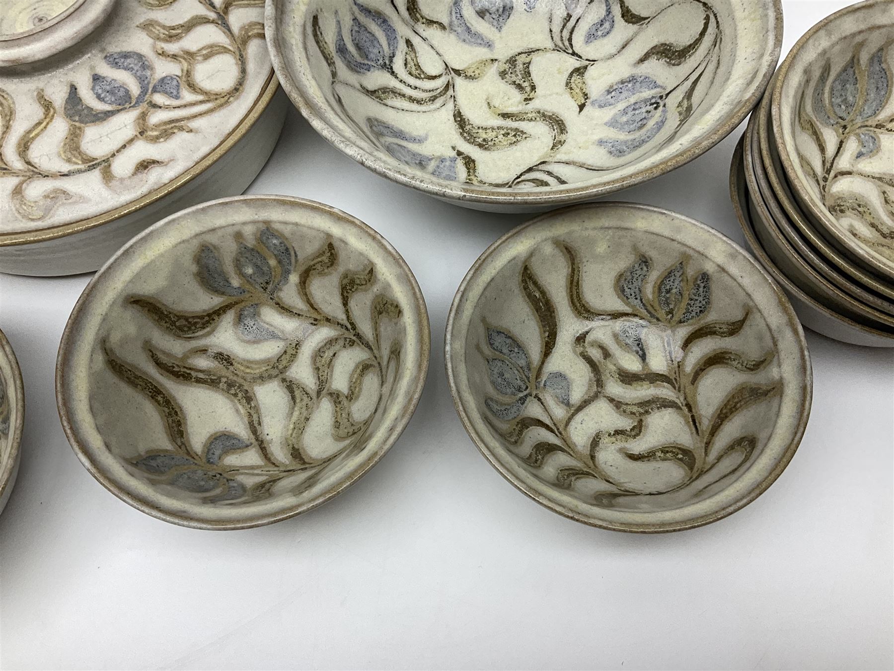 John Egerton (c1945-): studio pottery stoneware, comprising twin shallow covered dish, serving bowl and eight dessert bowls, all decorated with flowering sprigs on a cream ground, dish D28cm