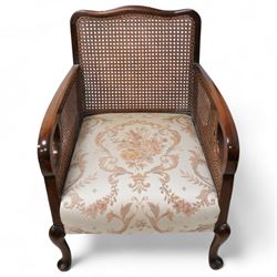 Early 20th century bergere lounge suite - two-seat sofa (W140cm, H80cm, D72cm); and pair of armchairs (W64cm); together with footstool, upholstered in floral fabric