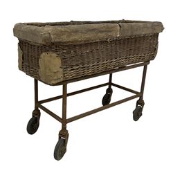 Early 20th century GPO wicker and hide bound postal trolley, on a cast iron base with castors