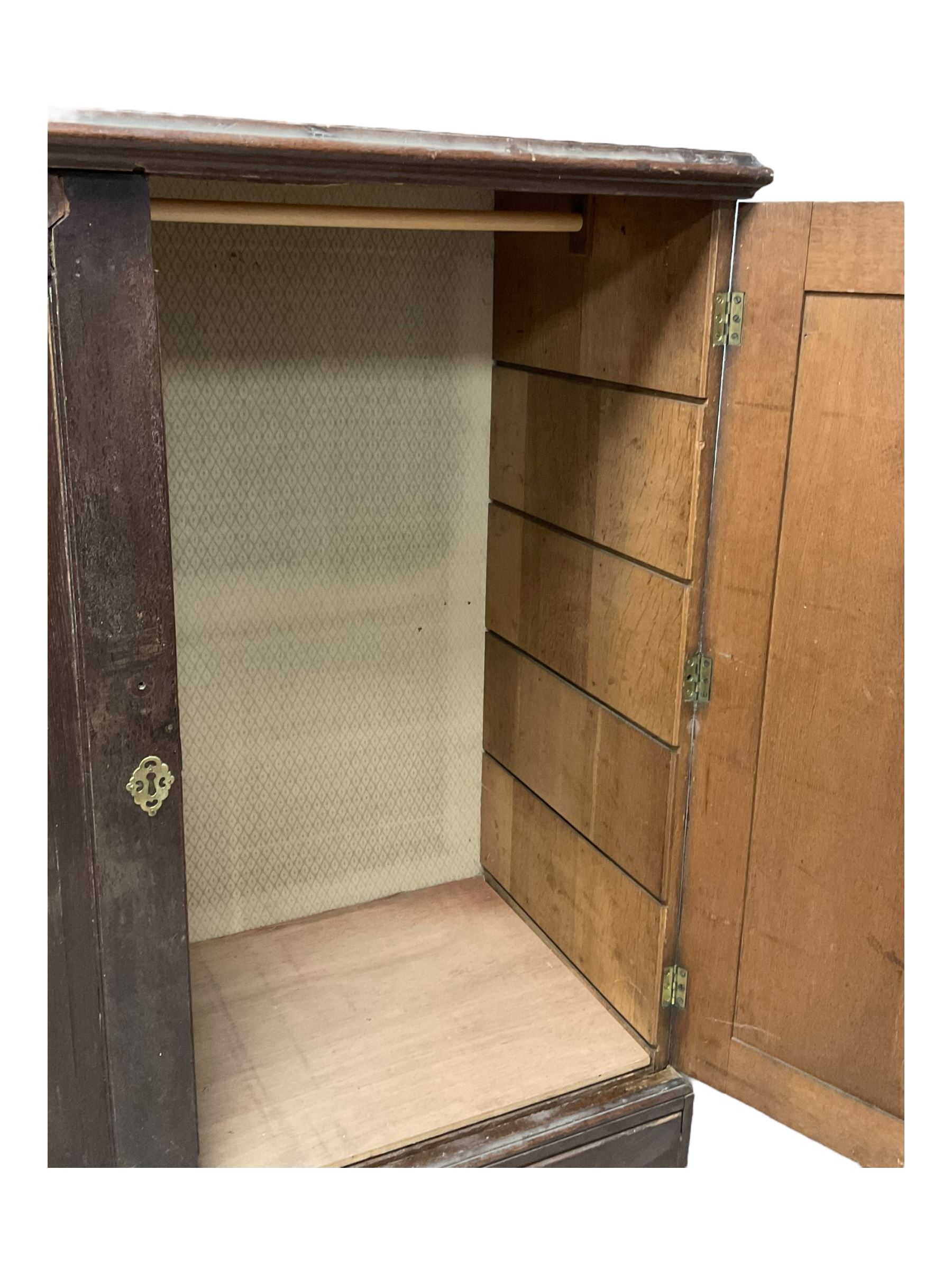 18th century oak linen press, moulded cornice over two panelled cupboard doors, the base fitted with two cock-beaded drawers with pieced brass escutcheons and handles, lower moulded edge on bracket feet