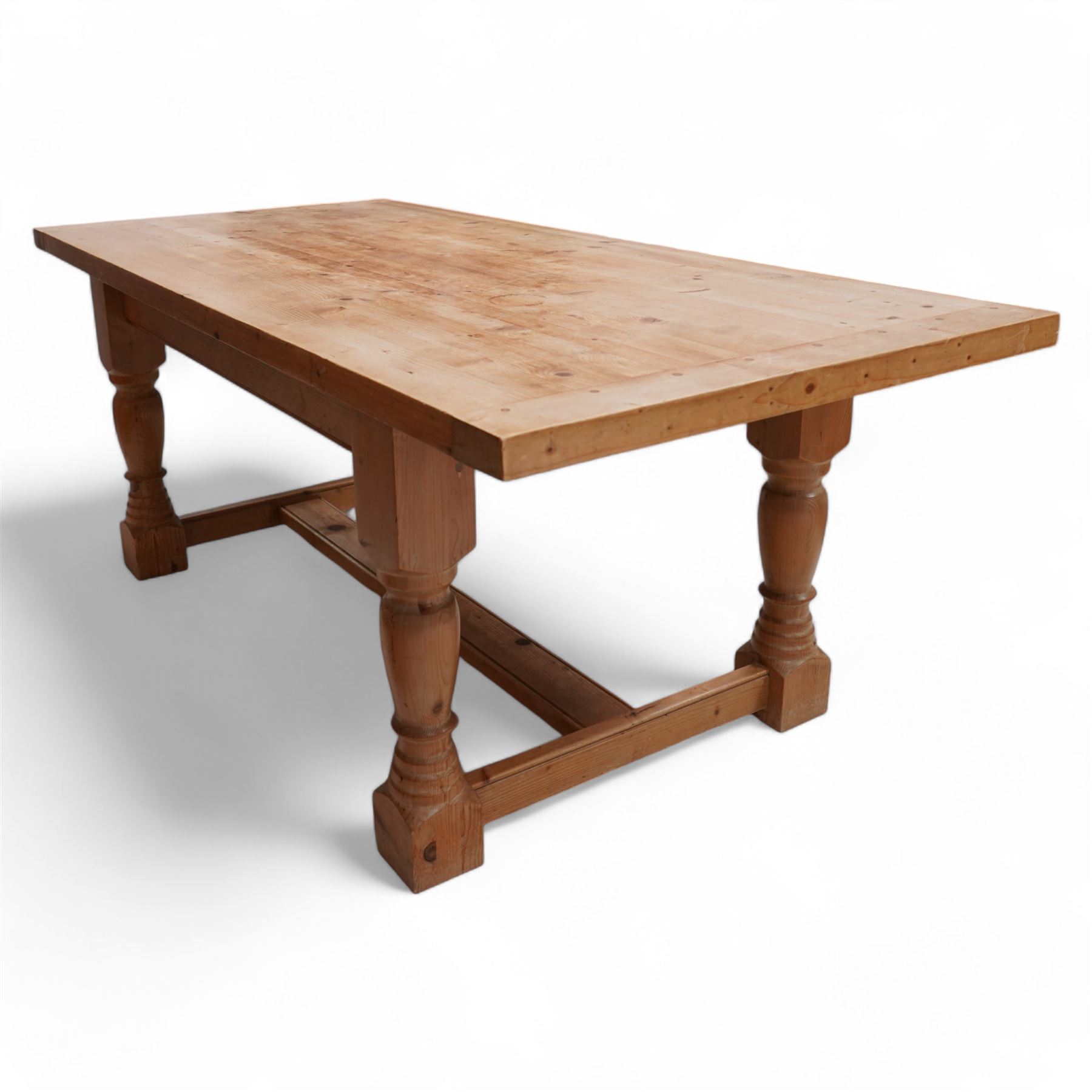 Waxed pine refectory table, boarded top with cleated ends, on turned supports united by H-stretchers 