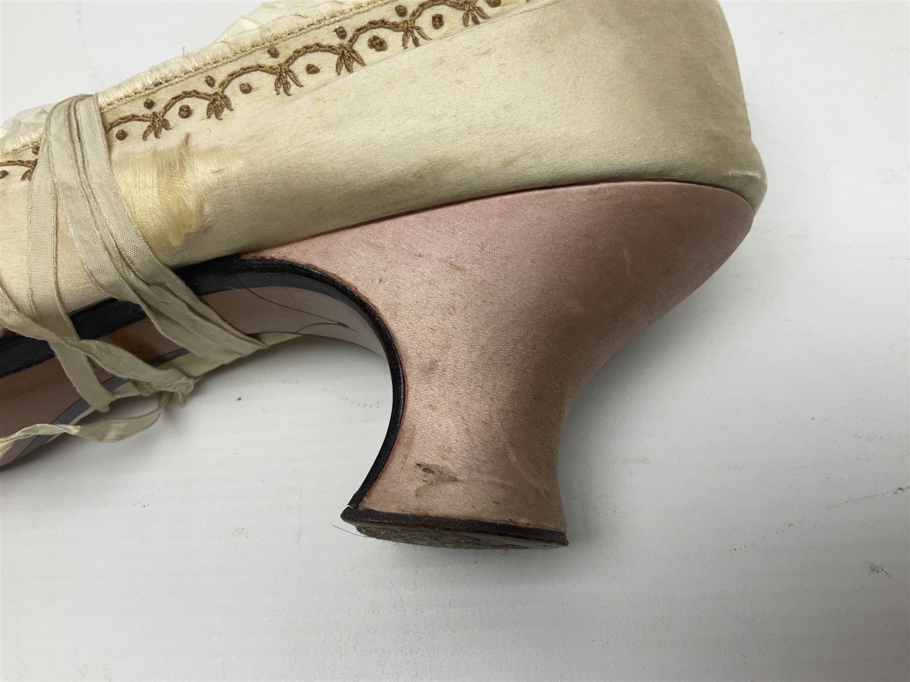 Pair of 19th century ivory silk satin ladies shoes, with rosette to the vamp, with pink silk satin heel, L23cm